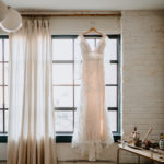 Lace wedding gown hanging in window